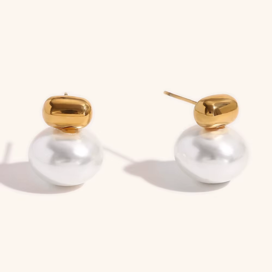 Gold and pearl earrings on a white background
