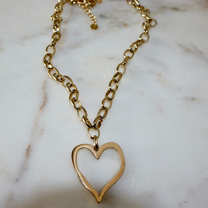 Gold heart-shaped pendant necklace on a marble surface