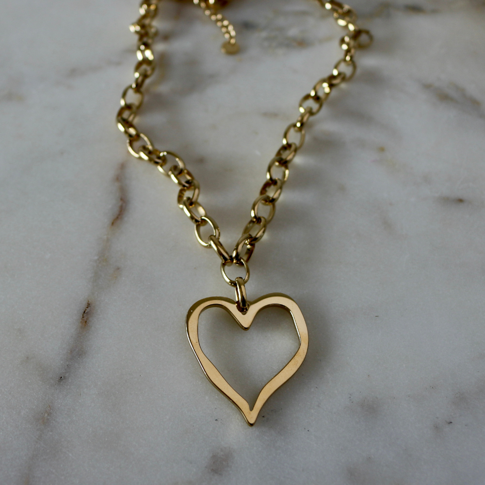 Gold heart-shaped pendant necklace on a marble surface