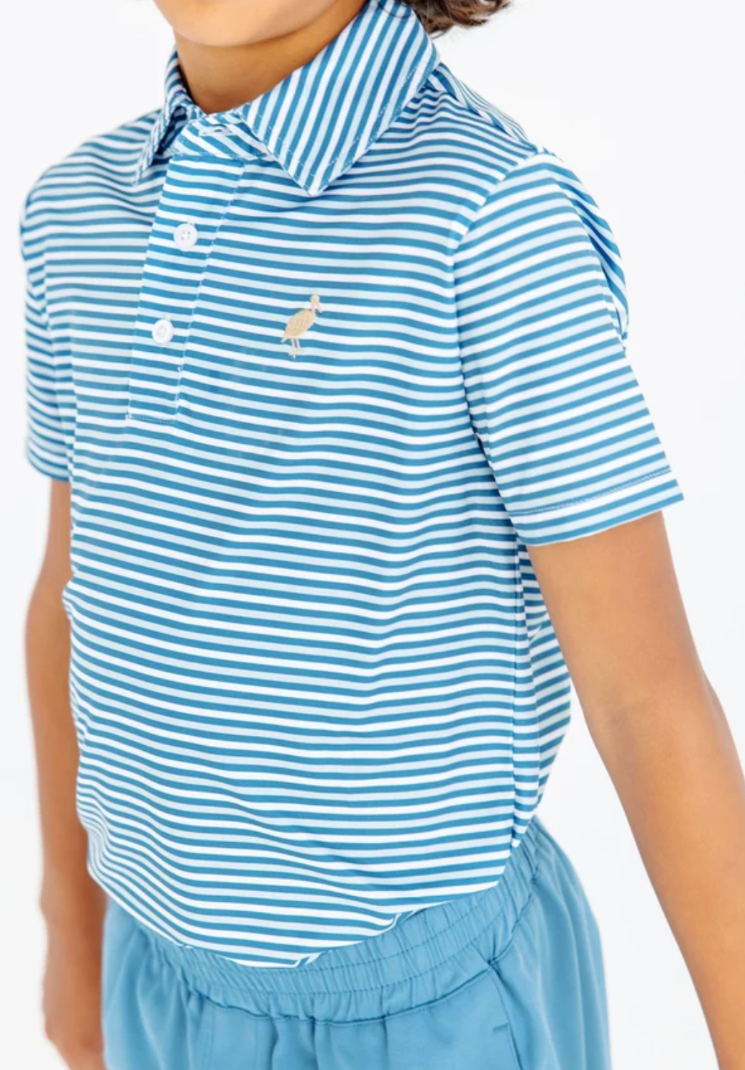 A child wearing a short-sleeve polo shirt with light blue and white horizontal stripes, featuring a small embroidered polo player logo on the chest, paired with light blue shorts against a plain white background.